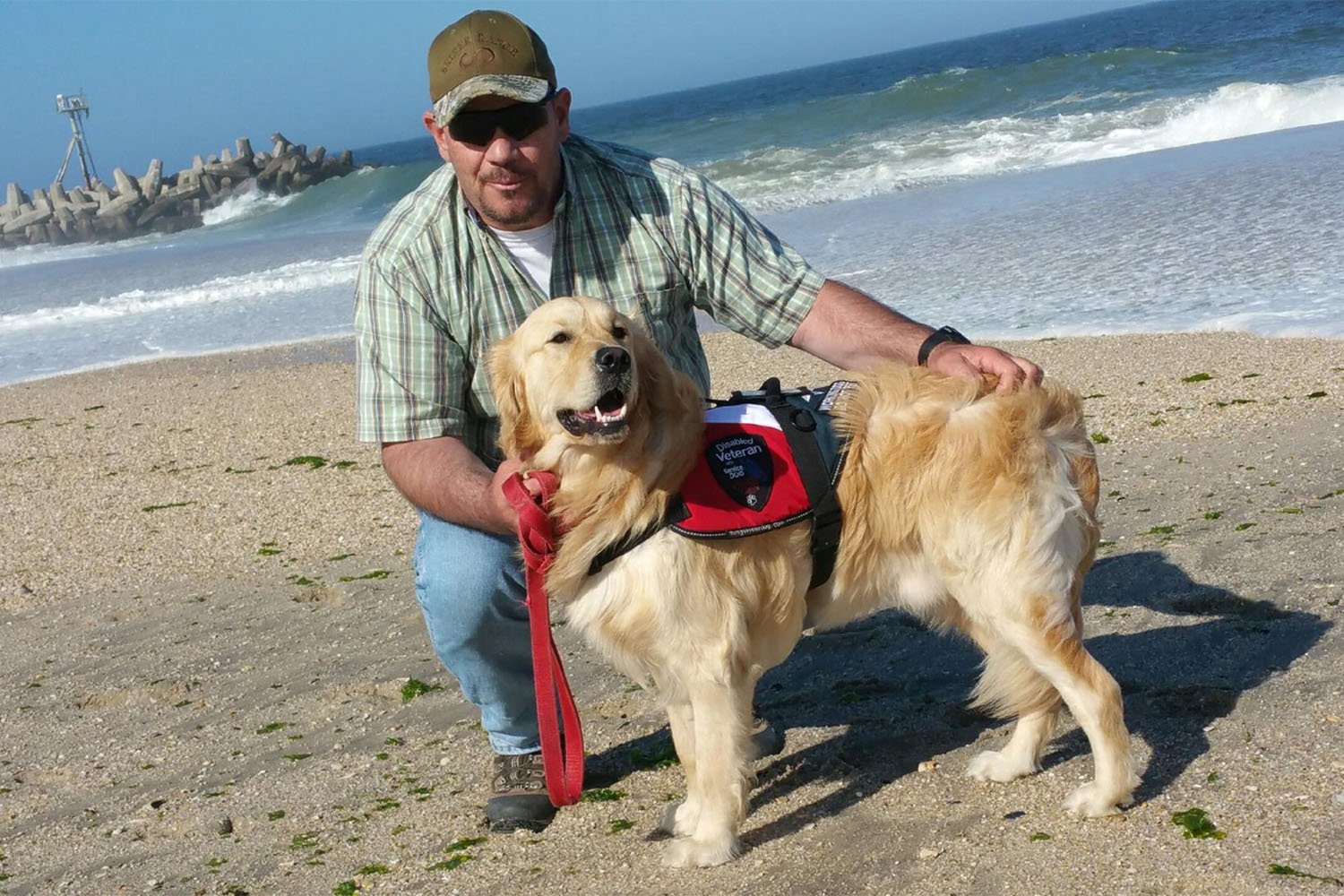 Vinny on a beach with his service dog Gabriel
