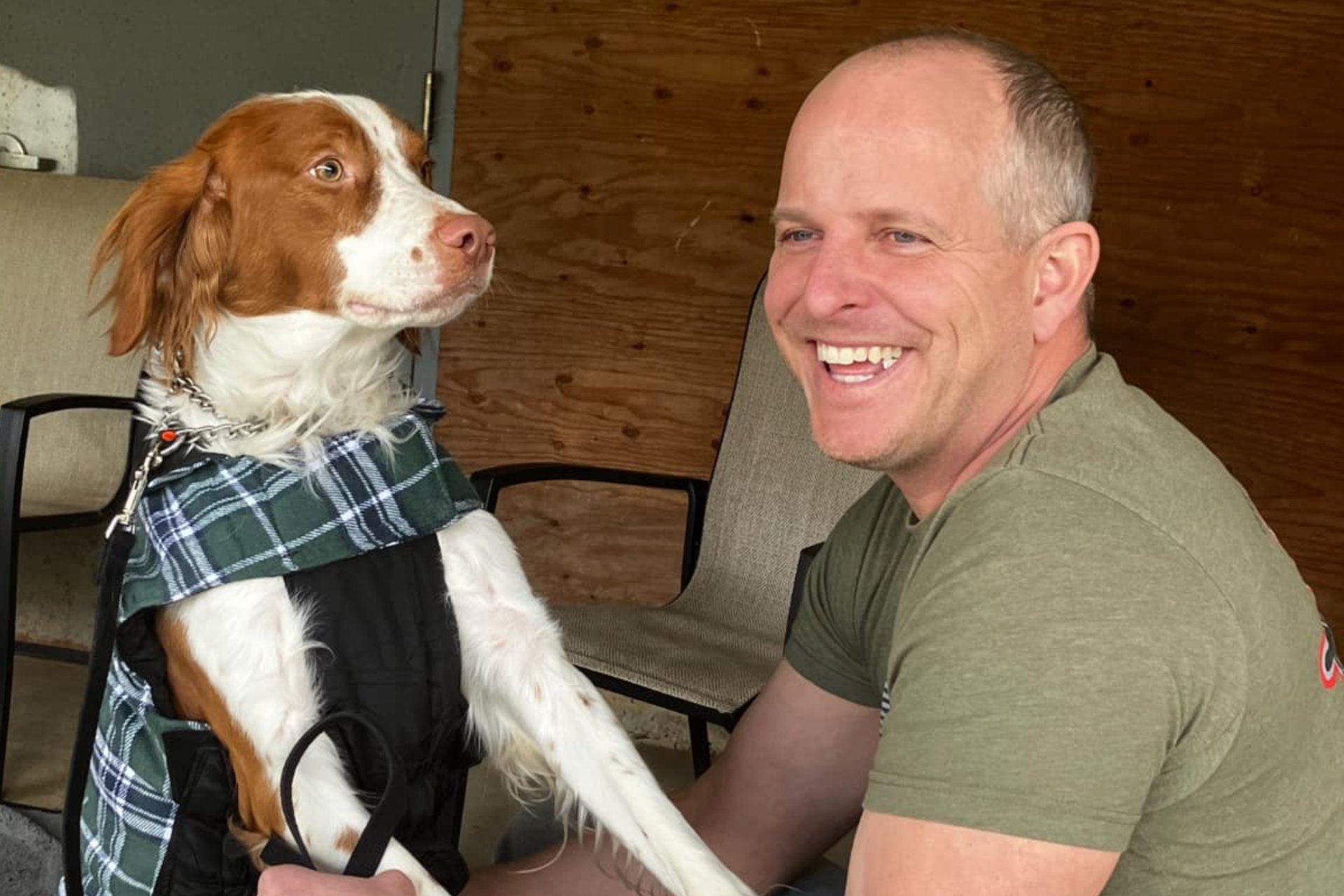 A Veteran smiles as his service dog puts his paws in his lap