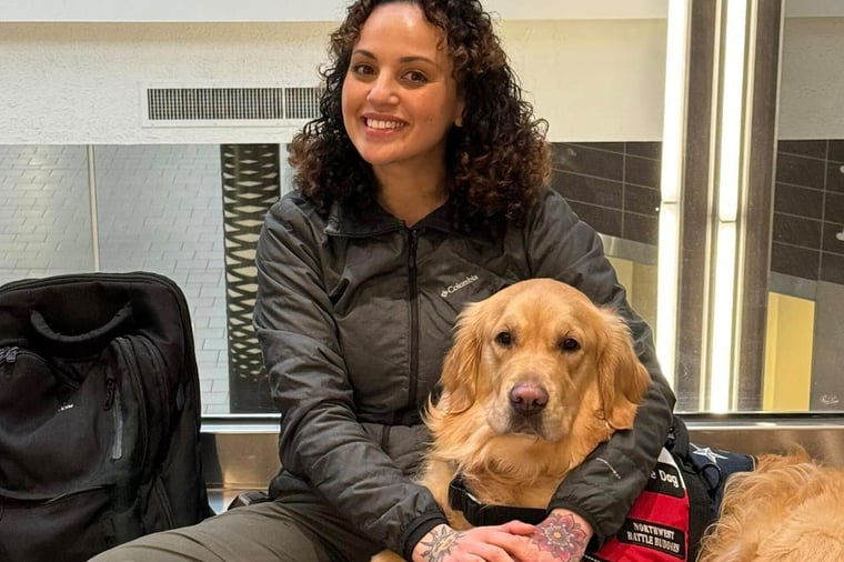 Veteran sitting with her service dog.