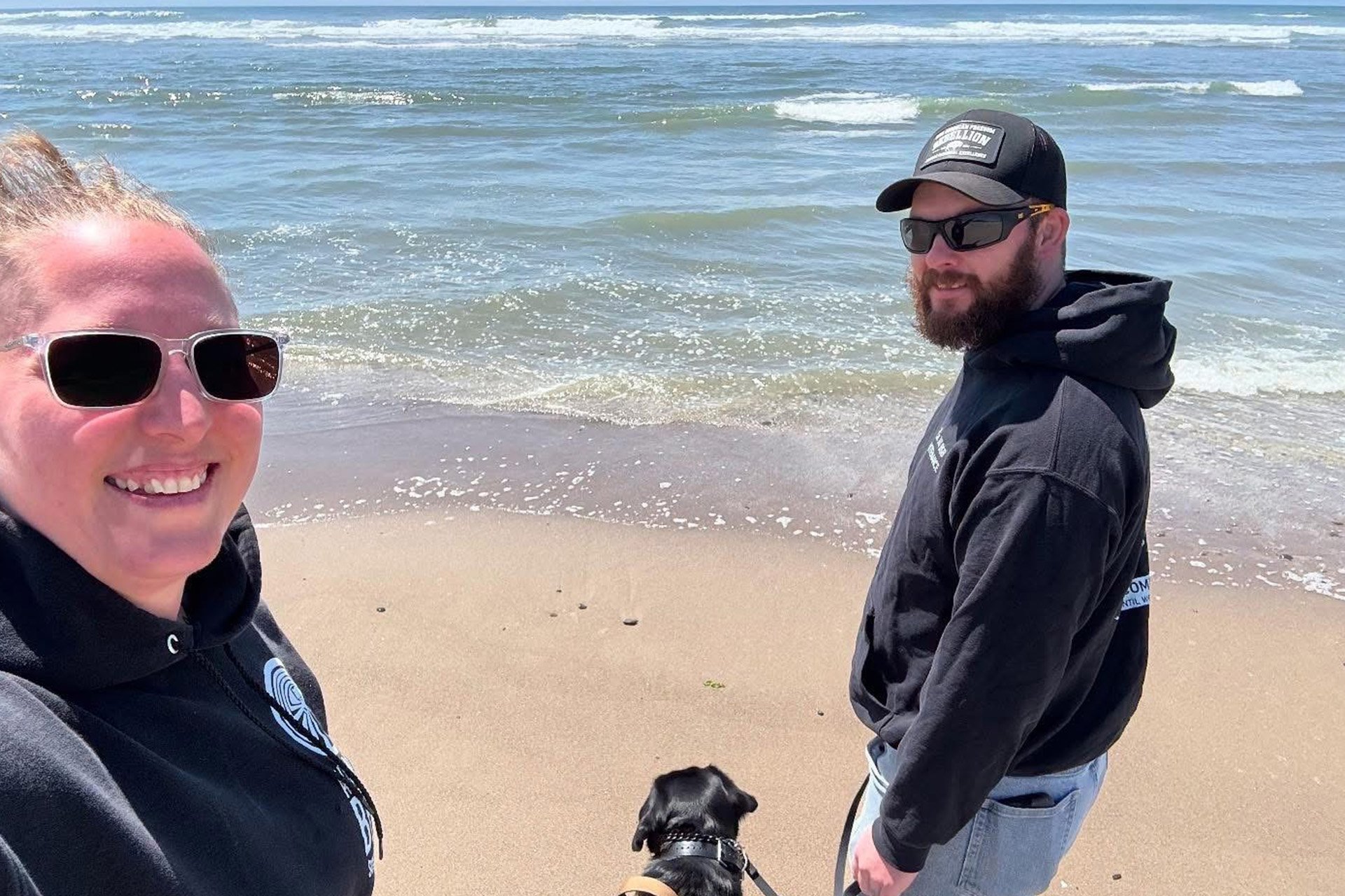 Derek and Melody with service dog Cora at the beach