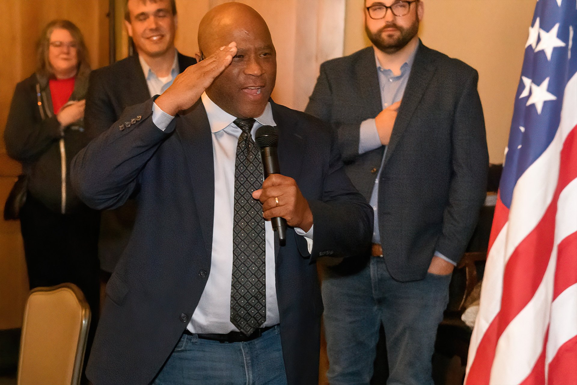 Officer Rey Reynolds saluting the American flag while singing the national anthem