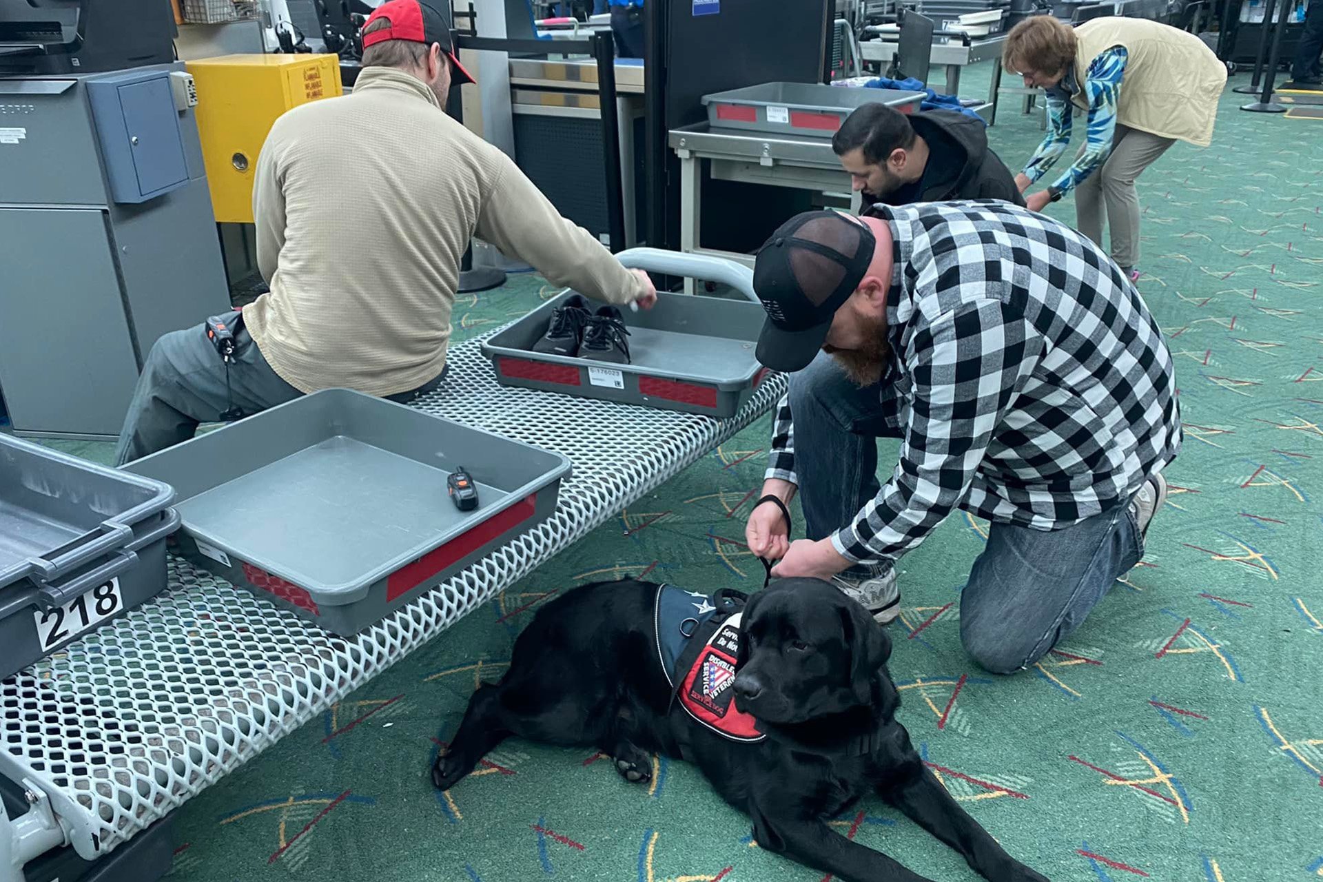 Man goes through airport security with his service dog