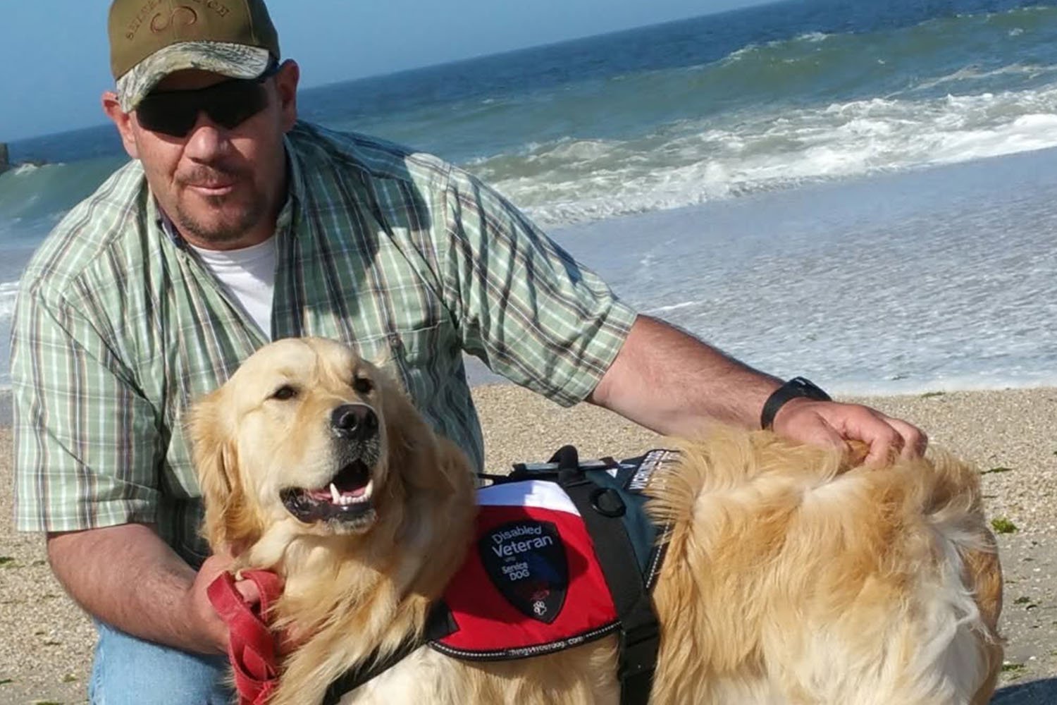 Vinny and his service dog Gabriel post on a beach