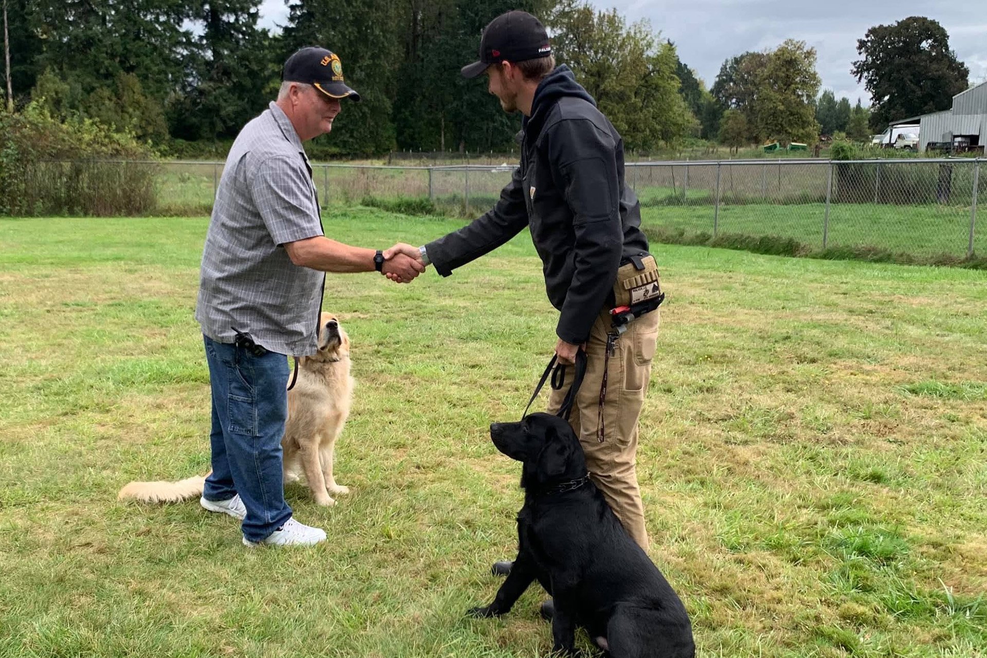 A Veteran and his service dog as the Veteran shakes hands with another man